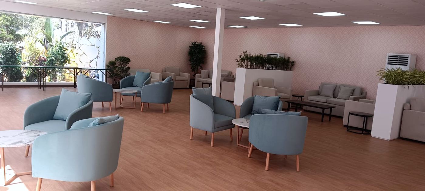 Corporate guest lounge with blue armchairs and a tower AC