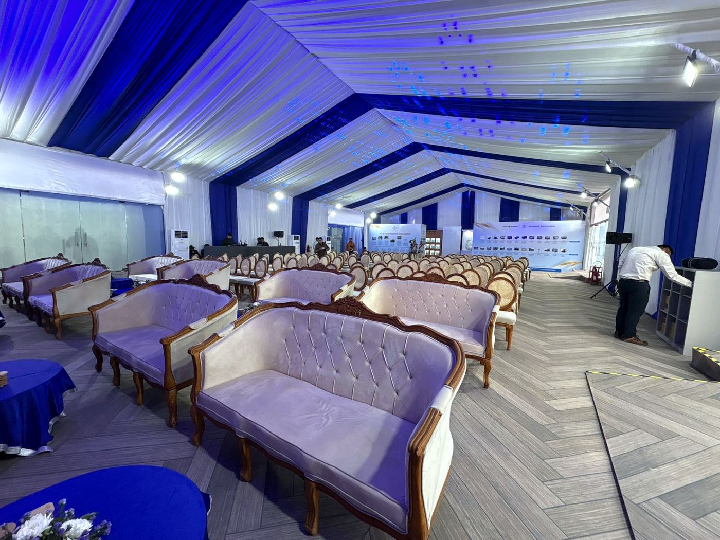 VIP hall with blue lighting and rows of white sofas